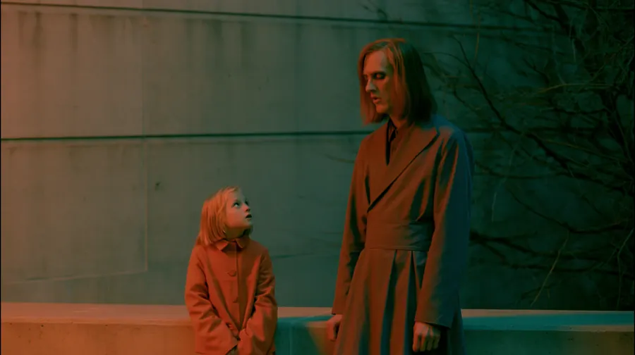 Cinematic frame from a ScreenWeaver film: a girl and a strange figure in red light